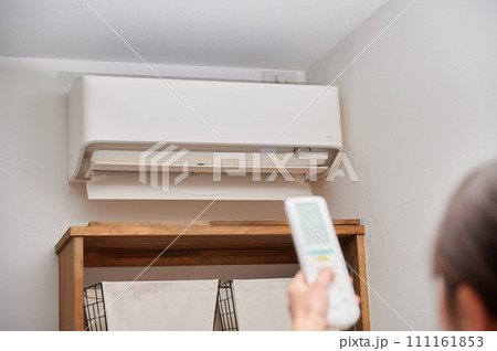 エアコンを操作する女性　リモコン 111161853