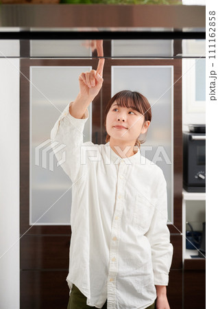 換気扇を操作する女性　掃除　レンジフード 111162858