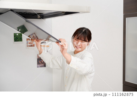 レンジフードを掃除する女性　換気扇　キッチン 111162875