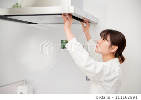 レンジフードを掃除する女性　換気扇　キッチン 111162891