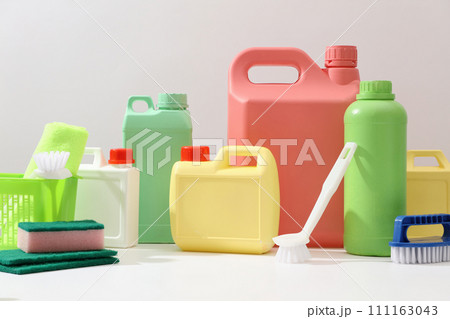 Front view of different bottle and canisters mockup of detergent product displayed on white background with cleaning tools. Housework and professional cleaning service supplies. 111163043