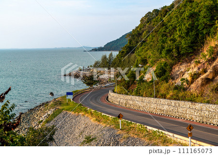 Beautiful view of evening sunset at the Noen Nangphaya view point looking out to the ocean and winding road along the coast in Chonburi, Thailand 111165073