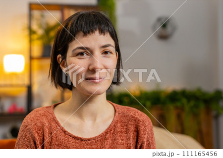 Portrait of smiling young happy Hispanic woman girl with short brown hair looking at camera at home 111165456