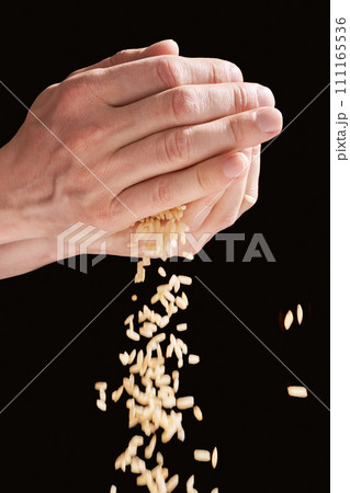 A hands hold a pile of rice, symbolizing charity, love, and hope. With cultural 111165536