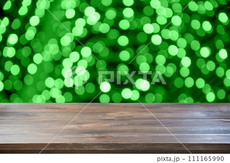 St Patrick's day defocused background. Empty wooden table top and green blurred garland. Abstract pattern for display your products. 111165990