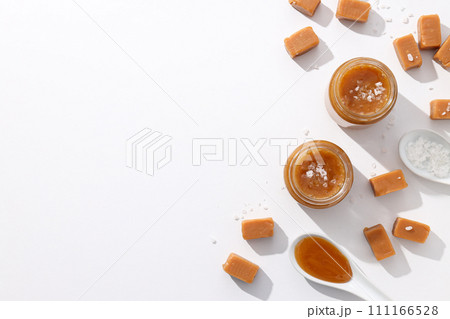Cubes of salted caramel with caramel in a jar 111166528