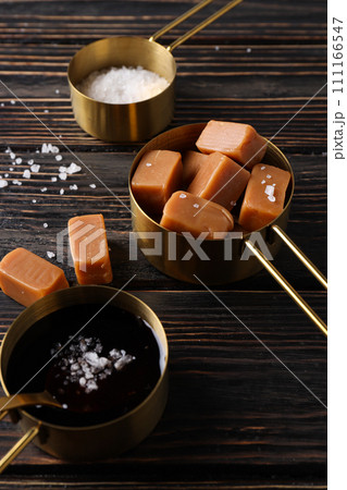 Cubes of salted caramel with salt on a wooden table 111166547