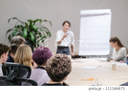 Professional female speaker leading workshop with attentive audience Professional female speaker leading workshop with attentive audience 111166673