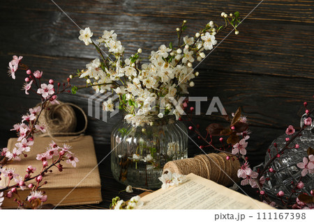 Spring twigs with flowers in a jar, on a dark wooden background. Spring twigs with flowers in a jar, on a dark wooden background. 111167398