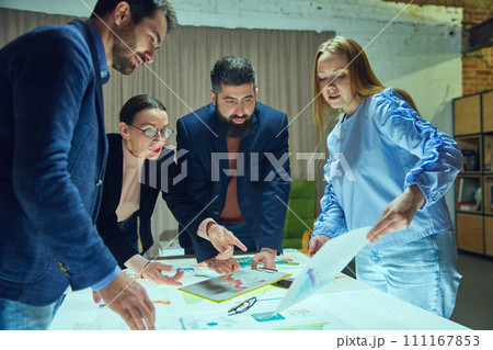 Group of professionals, colleagues engaged in strategic planning session with graphs and charts. Launching startup, working with analytics 111167853