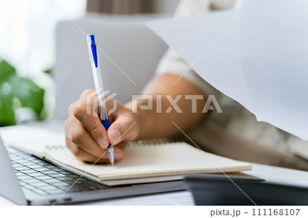 Man is calculating annual tax with calculator and filling form of Individual Income Tax Return. Season to pay Tax and Budget planning concept. Man is calculating annual tax with calculator and filling form of Individual Income Tax Return. Season to pay Tax and Budget planning concept. 111168107