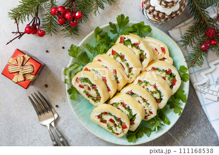 Creative appetizers christmas. Cheese roll with cream cheese, sweet pepper and greens. View from above. 111168538