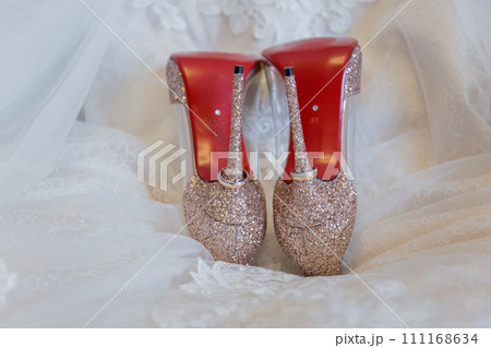 shoes of the bride with wedding rings on the floor 111168634