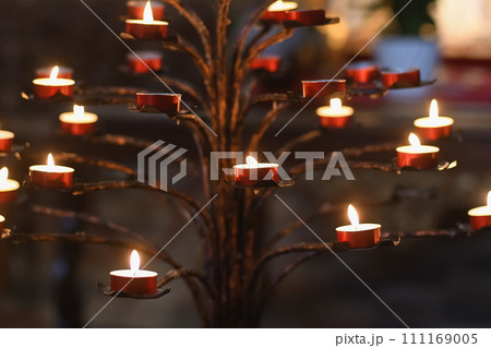 Many candles in the dark Catholic church 111169005