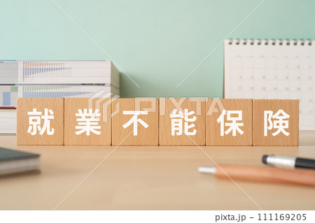 就業不能保険と書かれたブロックが置かれたデスク 111169205