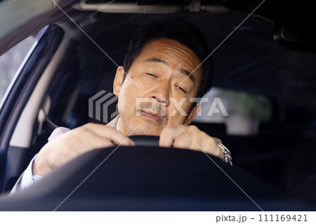 居眠り運転をする男性 111169421