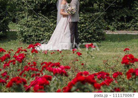 bride and groom in a park with flowers 111170067