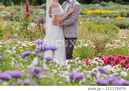 bride and groom in a park with flowers bride and groom in a park with flowers 111170070