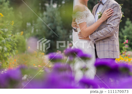 bride and groom in a park with flowers bride and groom in a park with flowers 111170073