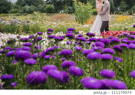 bride and groom in a park with flowers 111170074
