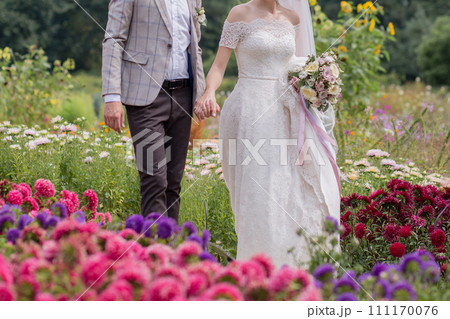 bride and groom in a park with flowers 111170076