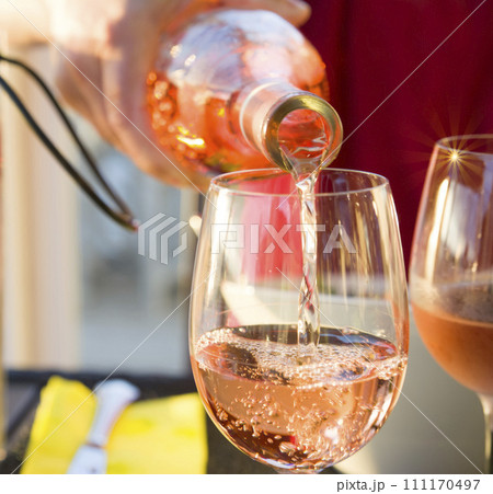 The waiter pours the pink french wine into the glass Sparks 111170497