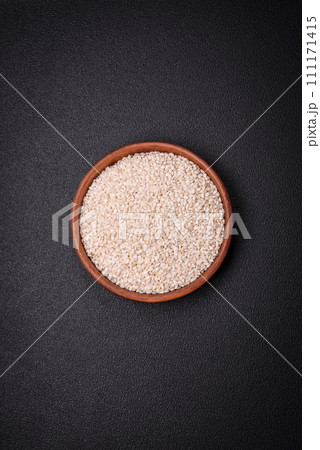 Large grains of uncooked white rice in a ceramic bowl 111171415