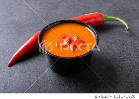 Spicy chili sauce in bowl on black background. 111171820