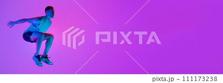 Athletic man in sportswear training, jumping against gradient pink background in neon light Athletic man in sportswear training, jumping against gradient pink background in neon light 111173238