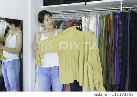 朝クローゼットの洋服を選ぶ若い女性 111173258