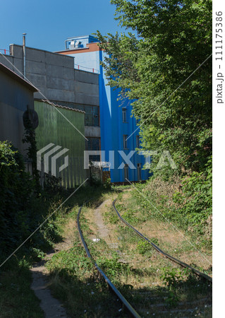 train rails near an industrial building 111175386