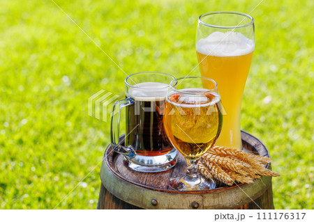 Variety of beer glasses on rustic wooden barrel 111176317