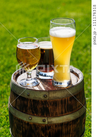 Variety of beer glasses on rustic wooden barrel 111176318