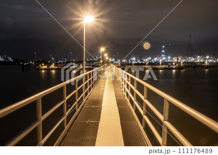 Pathway to the Night: Illuminated Pier Against City Lights 111176489