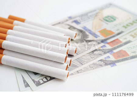 Cigarette on US dollar banknotes, cost, trading, marketing and production, No smoking concept. Cigarette on US dollar banknotes, cost, trading, marketing and production, No smoking concept. 111176499