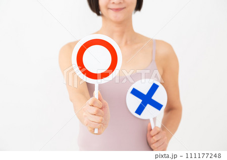 丸サインのプレートを持つキャミソール姿のミドル女性 111177248