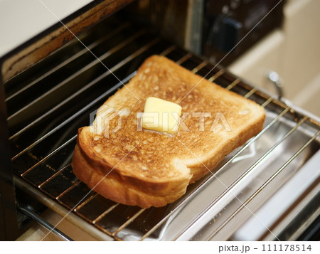 トーストした食パンの上にバターを乗せている 111178514