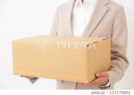 段ボール箱の荷物を持つスーツ姿のミドル女性 段ボール箱の荷物を持つスーツ姿のミドル女性 111178902
