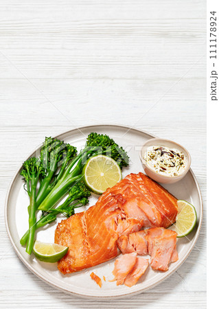 hot smoked salmon with cooked broccoli and lime 111178924