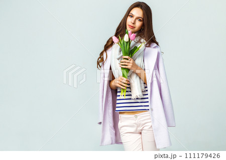 Fashion photo of beautiful woman with tulips in her hand. March 8. beautiful girl in stylish clothes Fashion photo of beautiful woman with tulips in her hand. March 8. beautiful girl in stylish clothes 111179426