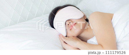 Beautiful young asian woman wearing cover eye and sleeping on bed with head on pillow. Beautiful young asian woman wearing cover eye and sleeping on bed with head on pillow. 111179526
