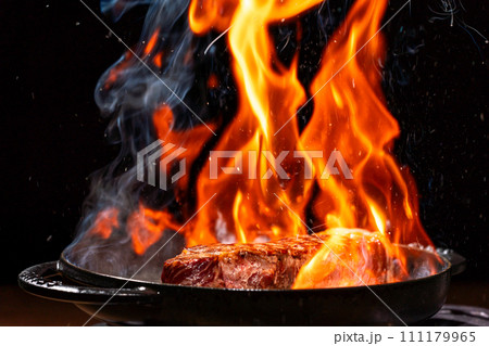 炎に包まれた調理中のサーロインステーキ 炎に包まれた調理中のサーロインステーキ 111179965