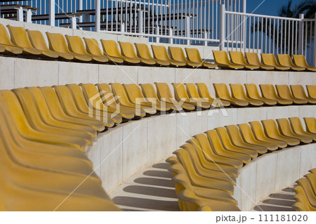 Rows of round stands with yellow outdoor seats for concerts and sports. Outdoor seating for spectators Rows of round stands with yellow outdoor seats for concerts and sports. Outdoor seating for spectators 111181020