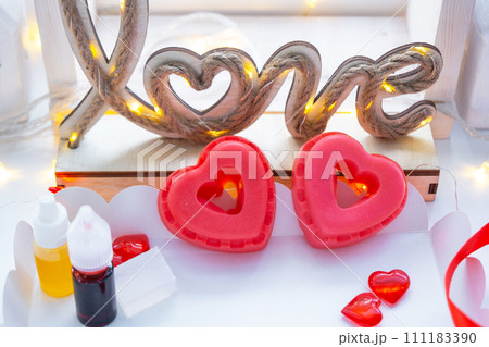 Handmade homemade soap in the shape of hearts for a Valentine's Day gift to your beloved. Perfumes and dyes, soap base on the table Handmade homemade soap in the shape of hearts for a Valentine's Day gift to your beloved. Perfumes and dyes, soap base on the table 111183390
