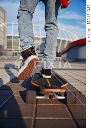 Closeup cropped view of stylish hipster man wearing sneakers riding skateboard Closeup cropped view of stylish hipster man wearing sneakers riding skateboard 111184383