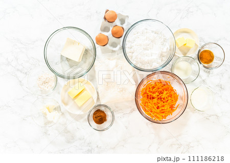 The measured ingredients are placed in mixing bowls on the counter, preparing to bake a scrumptious Carrot Bundt Cake from a cake mix. The measured ingredients are placed in mixing bowls on the counter, preparing to bake a scrumptious Carrot Bundt Cake from a cake mix. 111186218