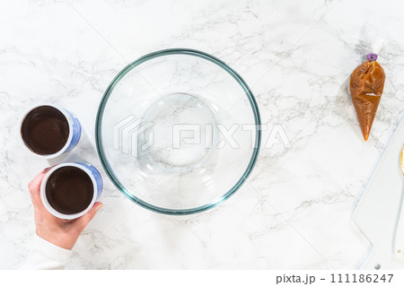 Flat lay. The frosting is whipped to perfection before being piped onto the delicious chocolate cupcakes. 111186247