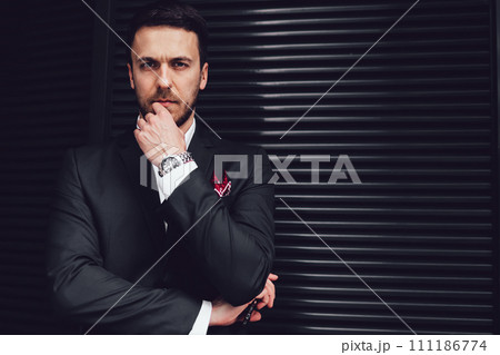 Thoughtful businessman making decision at building wall Thoughtful businessman making decision at building wall 111186774