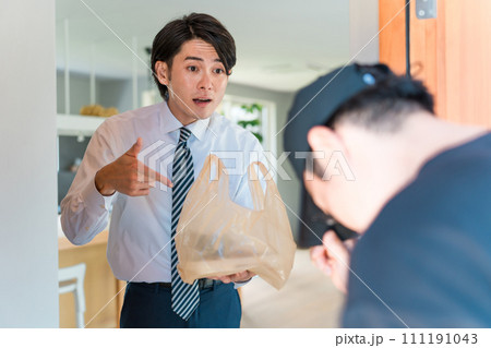 ウーバーイーツ・宅配弁当・デリバリー・配達・宅食・仕出し弁当の宅配のトラブルで怒る男性と配達員 111191043