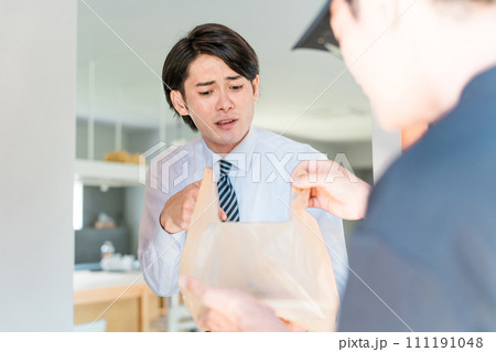 ウーバーイーツ・宅配弁当・デリバリー・配達・宅食・仕出し弁当の宅配のトラブルで怒る男性と配達員 111191048